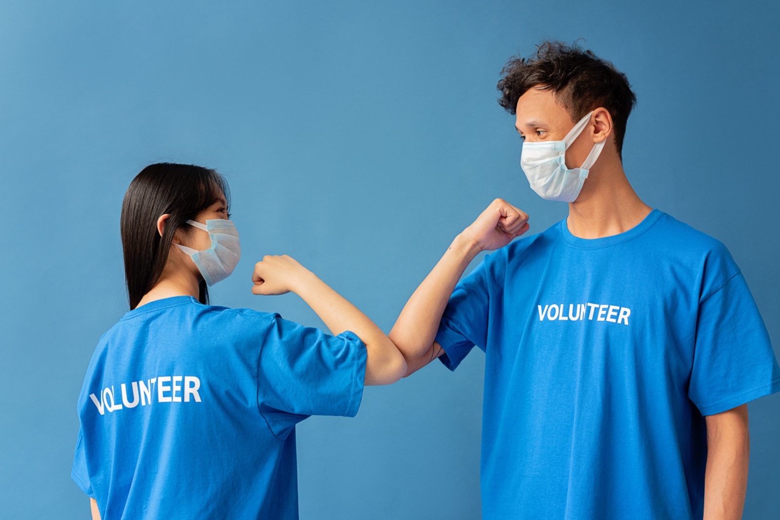 Two volunteers greeting each other safely