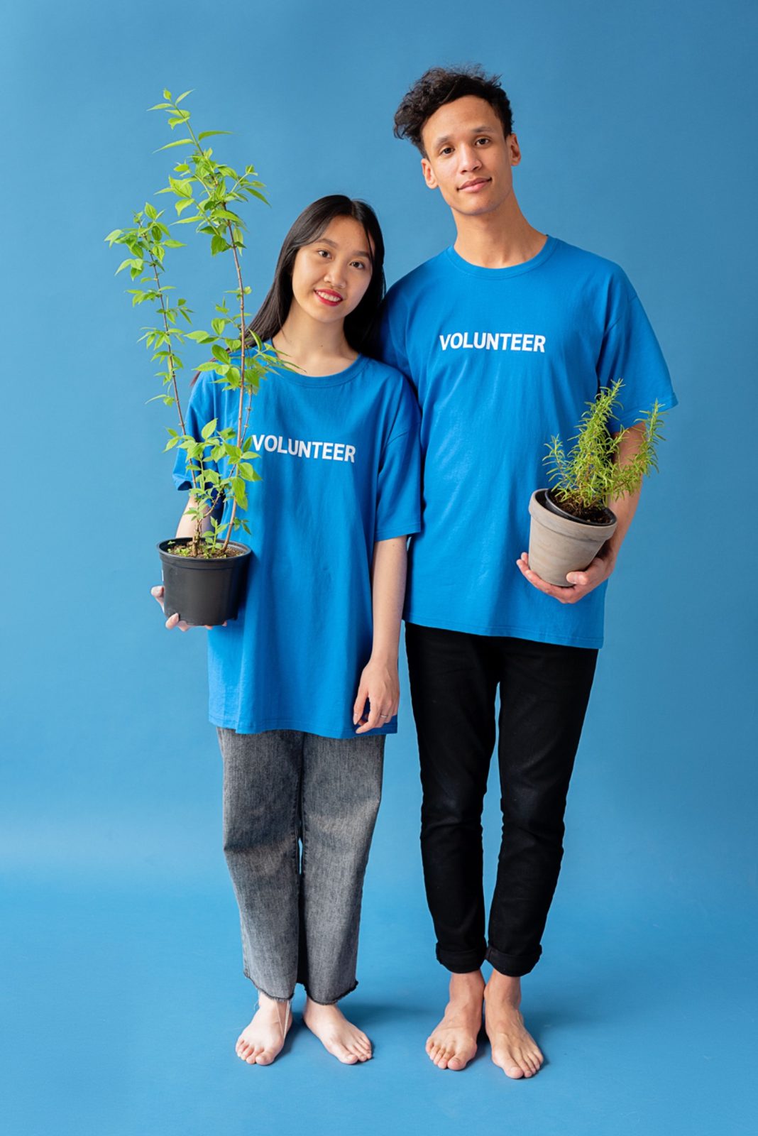 Two volunteers holding small plants